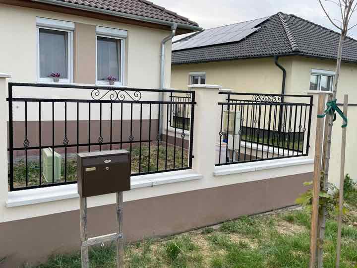 Kerítés díszes felső mintával és postaládával